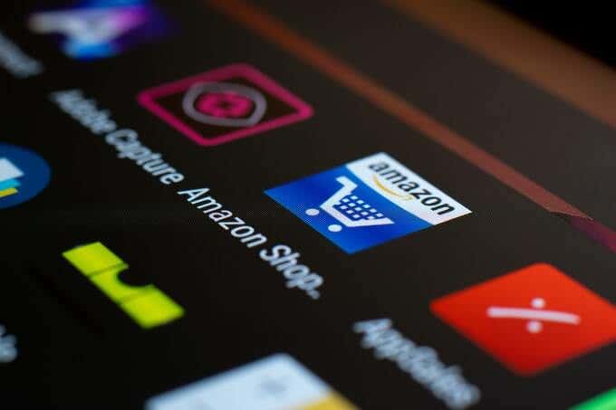 An Amazon shopping app icon is displayed on a phone screen among other app icons